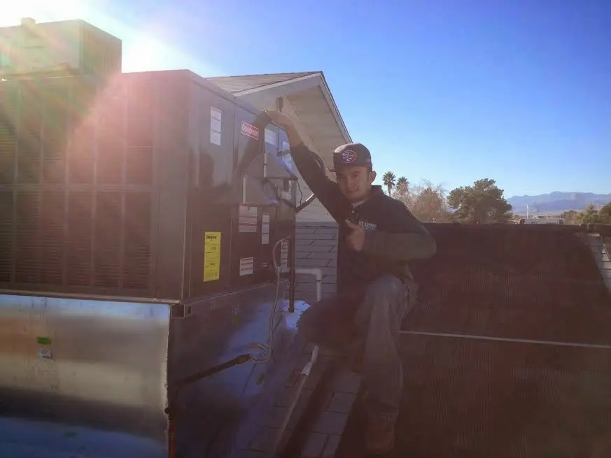 HVAC technician performing AC Tune-Up on a rooftop unit in Kenton